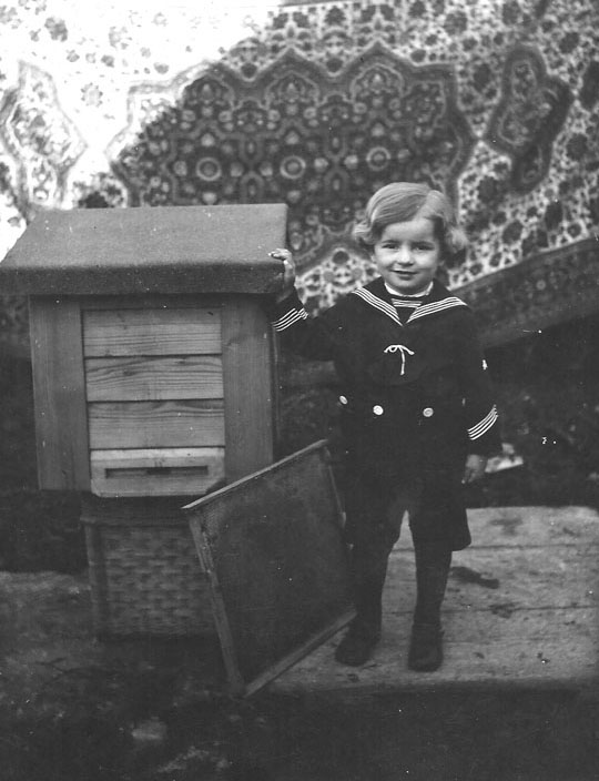 Charles Novacek, age 3 stands next to his father's bee apiary.  Ožďany, Czechoslovakia, 1938. 